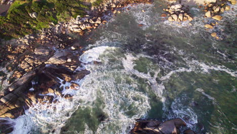 waves crashing on rocky shoreline in cape town captured from above with dynamic motion