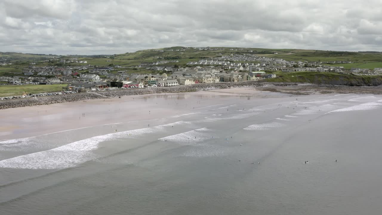 Veduta dall'alto di una spiaggia sabbiosa a Lahinch, Irlanda, dove i surfisti cavalcano le onde.