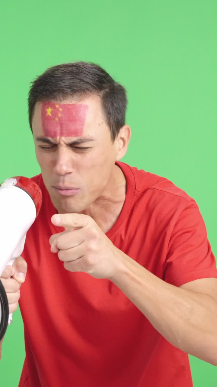 Excited man with chinese flag on face using a megaphone