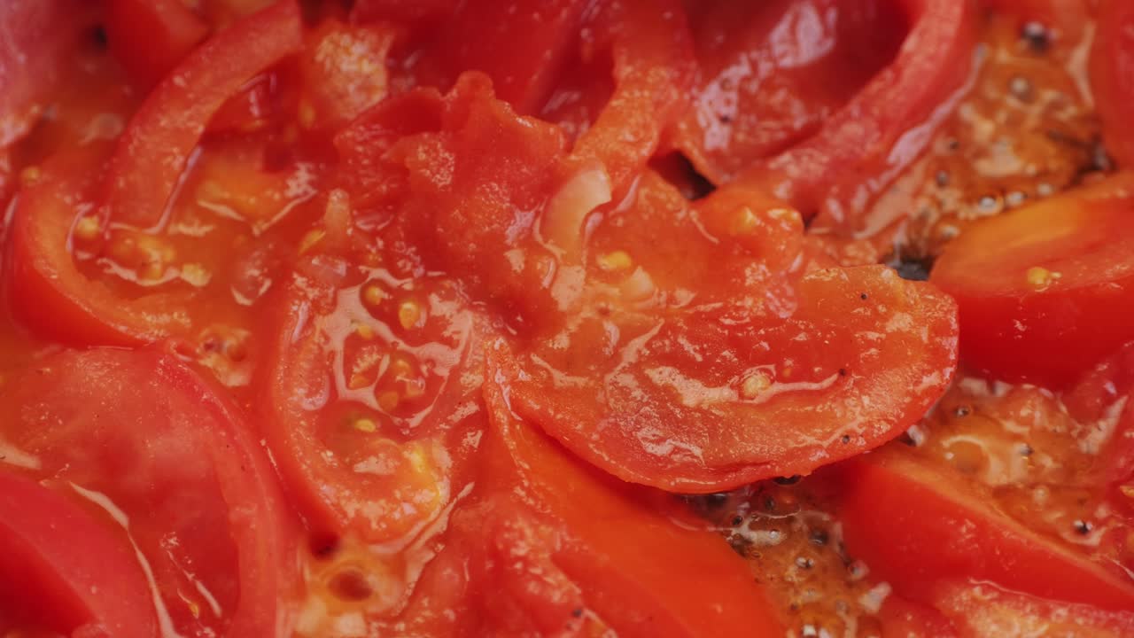 Cooking fresh peeled sliced tomato Juice sauce in pan, peeled tomatoes boiling in their own juice, making tomatoes pasta sauce .Top view close up, Italian traditional cuisine food.
