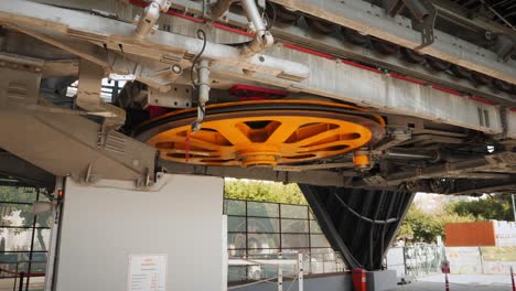 wheel of cable cabin lift rotating and moving cabins up. wheel rotates cable which moves cabin with passengers. modern cable road lift
