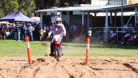 rider maneuvers motorcycle around barrels in race