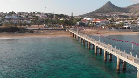 flying past a walkway leading into the ocean with the town buildings of porto santo in view