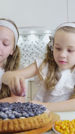 two girls sharing a blueberry pie