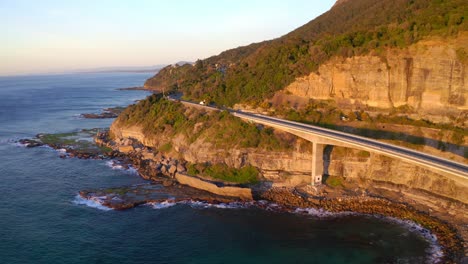 sea cliff bridge at the edge of sandstone cliff during sunset in new south wales, australia