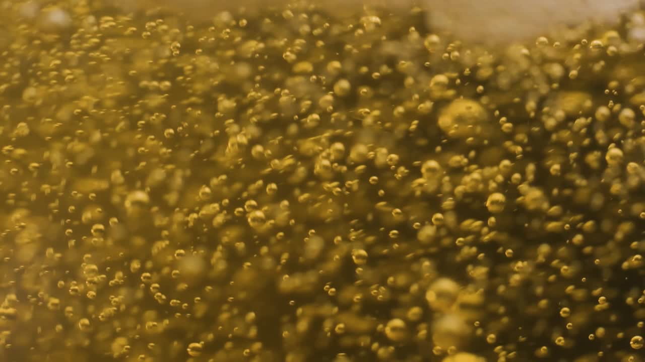 Extreme macro shot Pouring Champagne on Glass, Foam and bubbles explosion