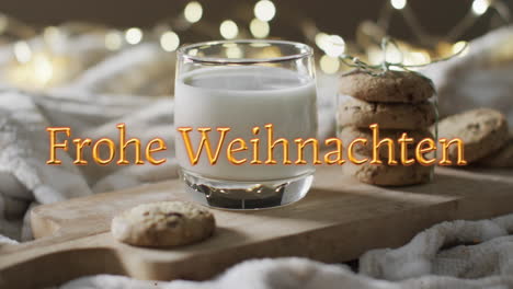 frohe weihnachten text in orange over christmas cookies and milk with bokeh lights