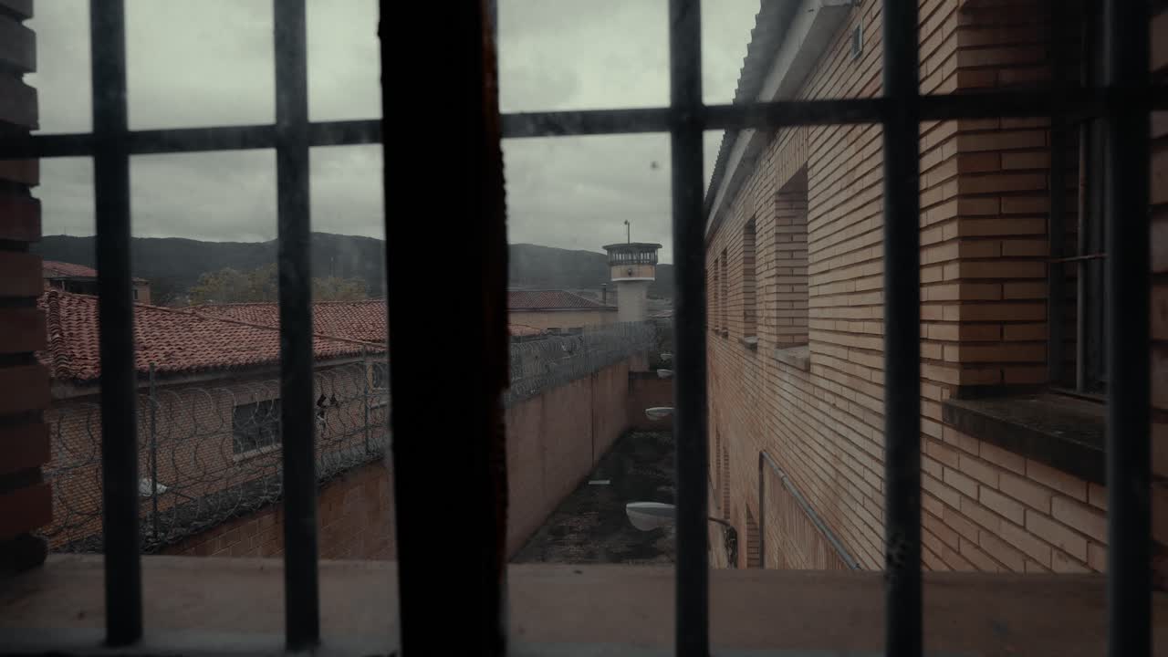 Gloomy View from Prison Cell Window with Bars and Watchtower