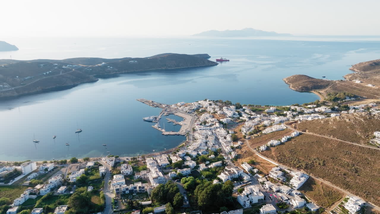 Livadi village marina and port, white houses, hotels near Aegean sea, Serifos, Cyclades Island, Drone shot