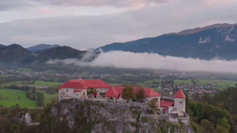 Castillo-Medieval-Esloveno-En-La-Isla-De-Bled-Con-Los-Alpes-Julianos-Al-Fondo-En-Bled,-Eslovenia