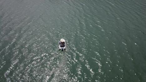 aerial downards and upwards shot of people in white boat on lake water