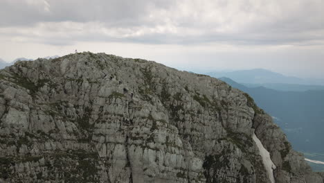 drone shot of mountain rombon, a flag waves at the top, visible other mountains and the valley