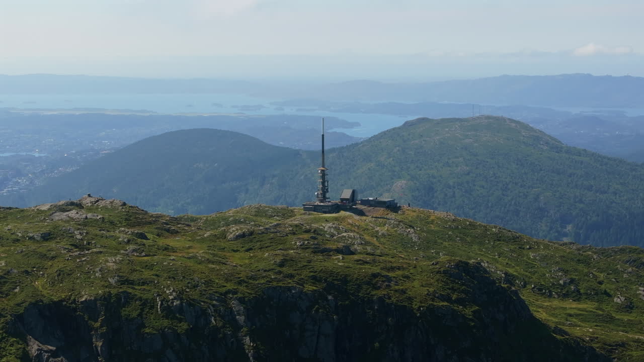 Wide aerial circle around the summit of Mount Ulriken, revealing its natural beauty and surrounding landscapes