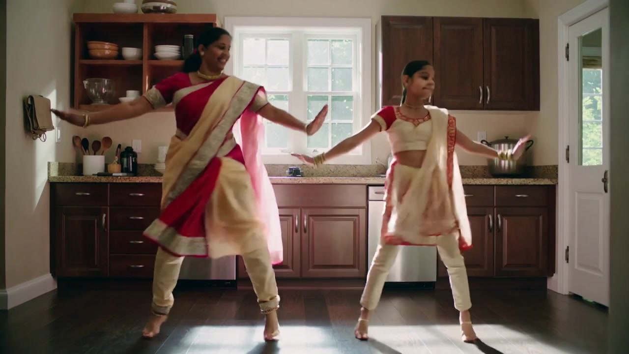 Madre e figlia che si esercitano, iniziando fianco a fianco, entrando in cucina indossando saree, salwar e ghungroo.