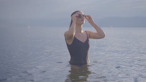 Joven-Atractiva-Con-Gafas-De-Sol-En-Un-Lago