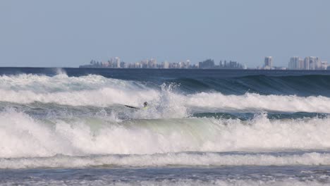 surfer catches and rides a wave to shore