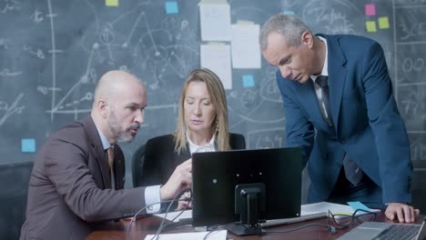 colleagues negotiating while meeting in boardroom