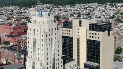 Aerial-revealing-shot-of-tall-skyscrapers-in-American-urban-city,-Reading-Pennsylvania-USA,-financial-district,-courthouse,-office-buildings,-apartment-housing,-church,-cityscape-during-summer-day