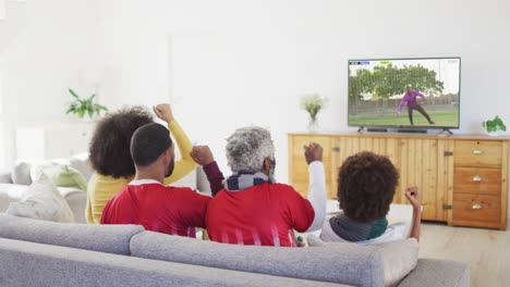 video of african american family sitting on the couch and watching football match