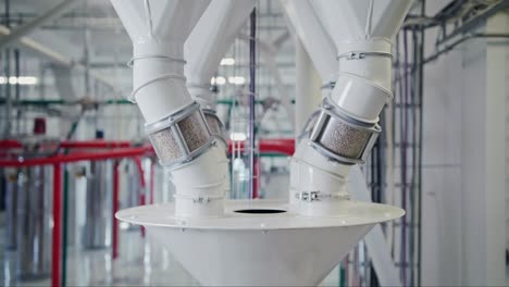 grain going through transparent inspection tubes at a state-of-the-art grain mill facility, showcasing large-scale food production on an industrial level