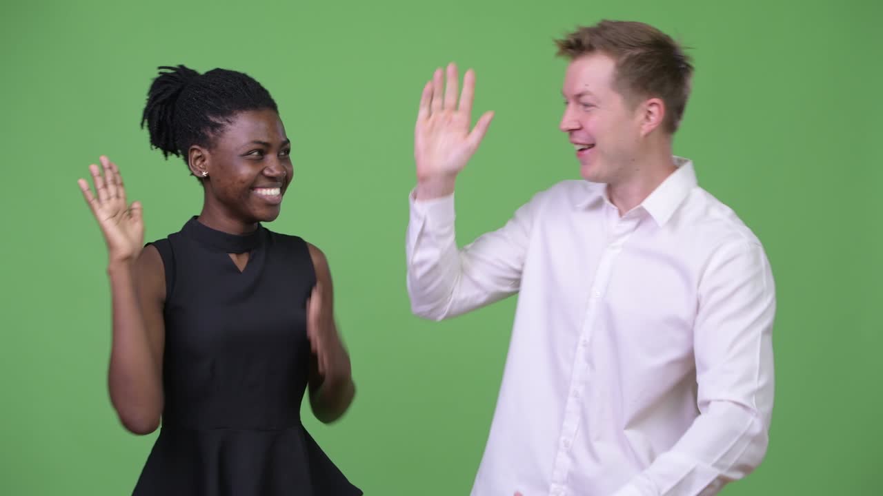 Two young multi-ethnic business couple looking excited together