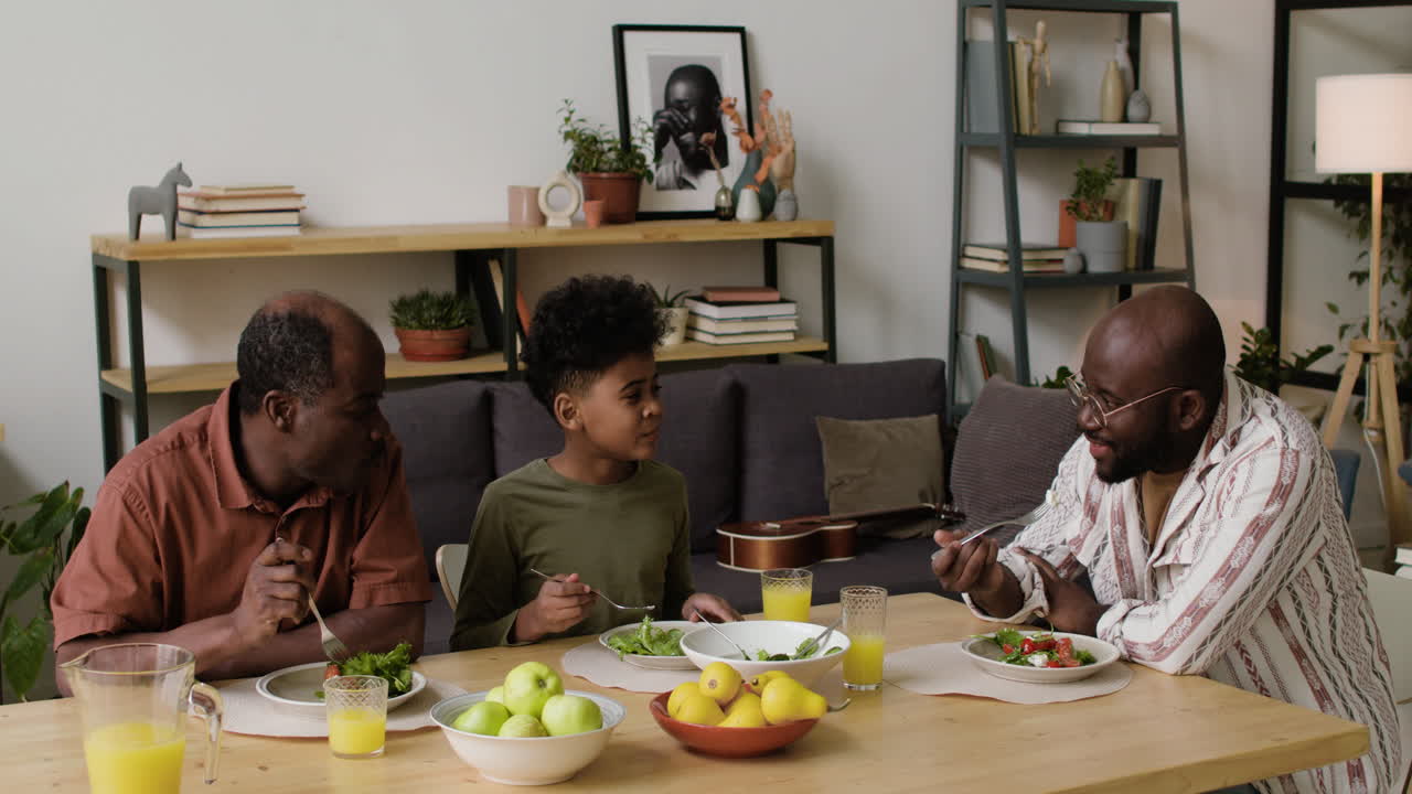 Black men and boy eating lunch at home