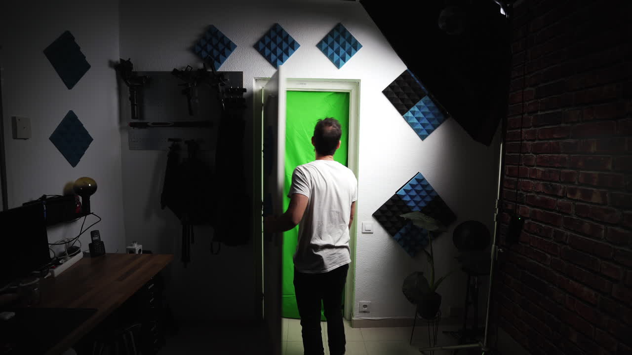 autónomo creativo caucásico que trabaja en su estudio de casa profesional, caminando descalzo abriendo una puerta blanca con pantalla verde