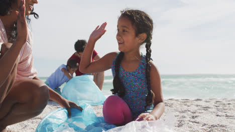 Feliz-Familia-Hispana-Recogiendo-Basura-En-La-Playa