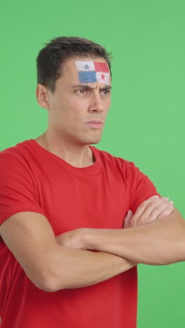 Man with panamanian flag painted looking away with serious expression