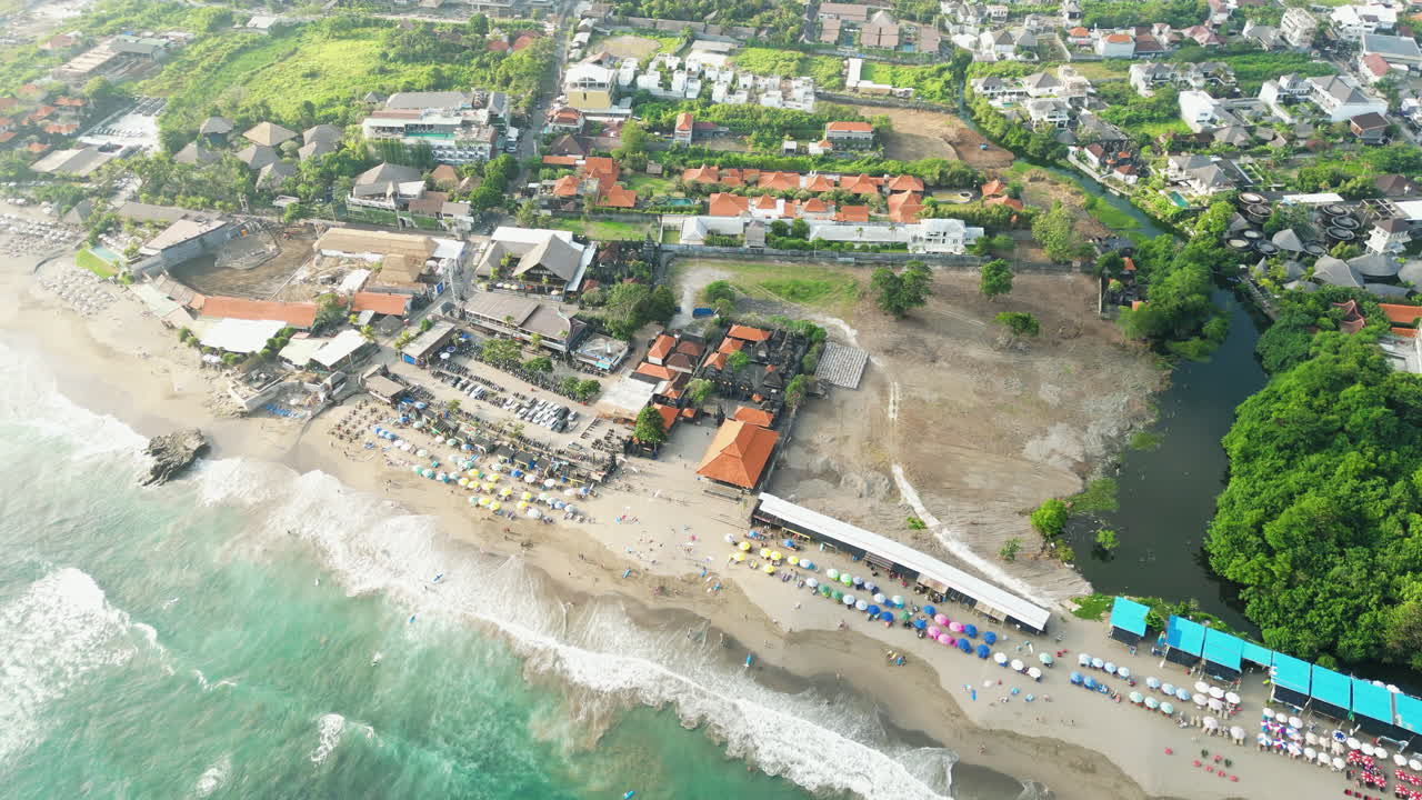 Beach resort and housing in Canggu beach, aerial drone orbit view