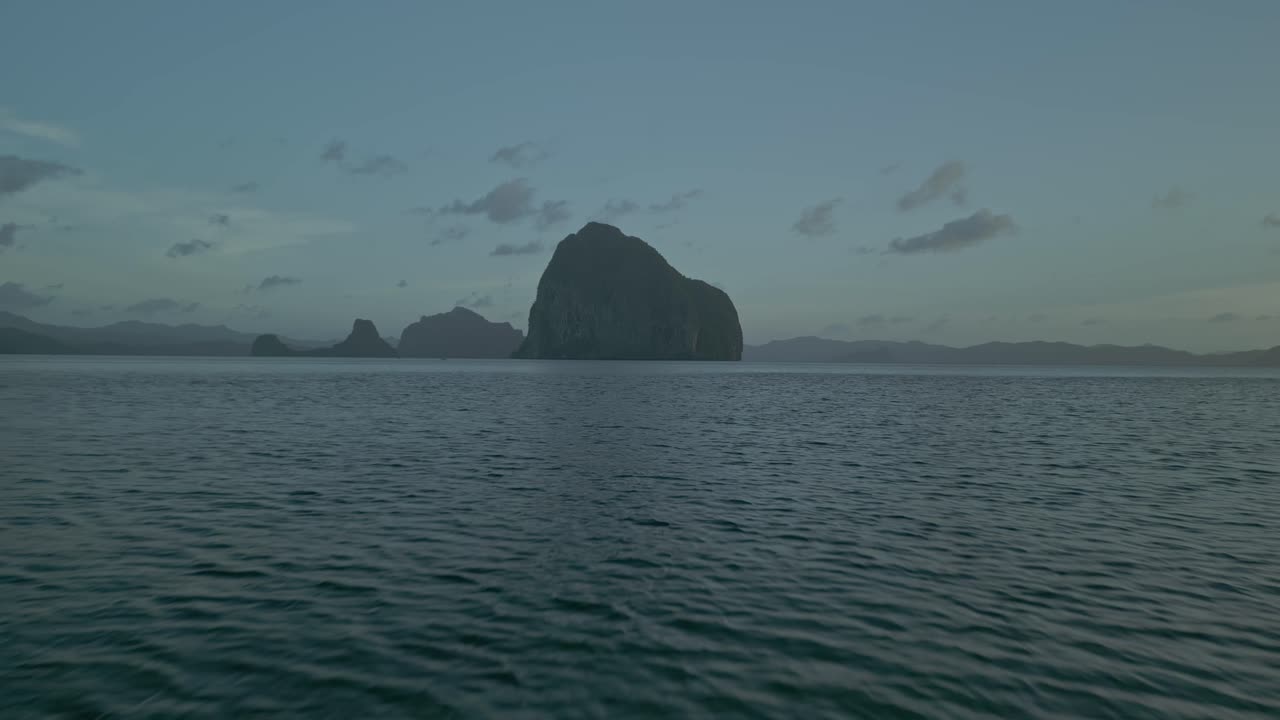 Tropical Seascape with Large Rock Formation at Dusk