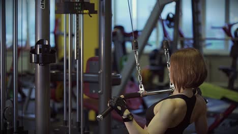 Woman doing lat pulldowns in a gym