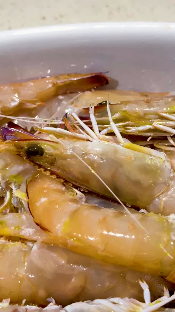 손 은 접시 에 있는 새우 에 소금 을 뿌린다