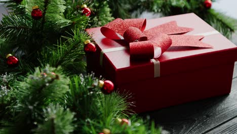 Weihnachtsgeschenk-In-Der-Nähe-Von-Nadelbaumzweigen-Mit-Perlen