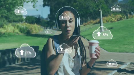 animación de nubes con flechas sobre mujer hablando en un teléfono inteligente en un parque
