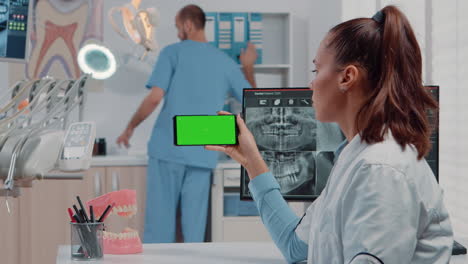 woman working with horizontal green screen on mobile phone