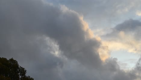 Un-Lapso-De-Tiempo-De-Las-Nubes-Moviéndose-Por-El-Cielo-En-Un-Día-Tormentoso-Y-De-Mal-Humor-Con-Un-árbol-Moviéndose-Con-El-Viento