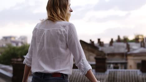 view from behind of beautiful woman stands on the balcony or terrace in apartment at day time