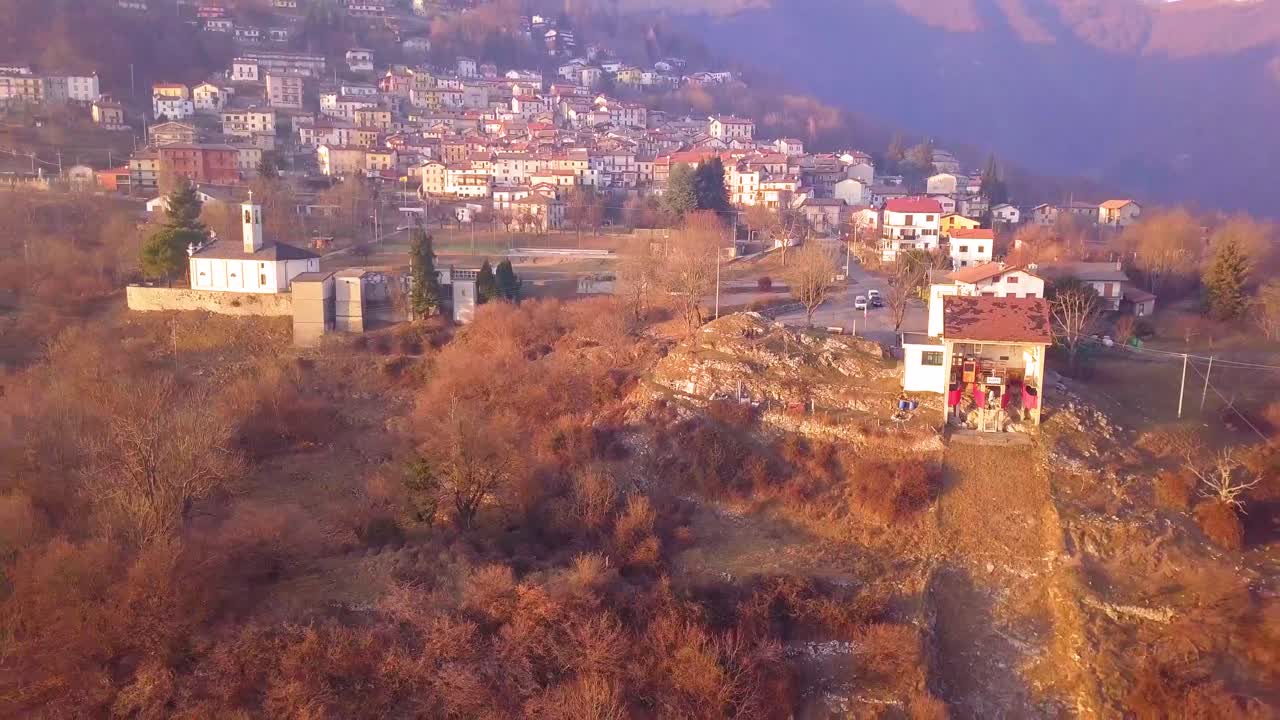Luftopptak av en drone som flyr vekk fra en liten landsby i Nord-Italia.