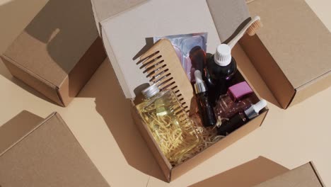 vertical video of beauty products in cardboard box with boxes and copy space over brown background