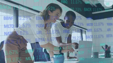 Animation-of-trading-board-over-diverse-female-coworkers-discussing-reports-on-laptop-in-office