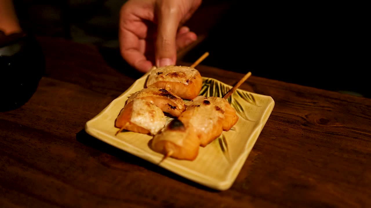 나무 테이블 에 살몬 요리 를 제공 하는 손