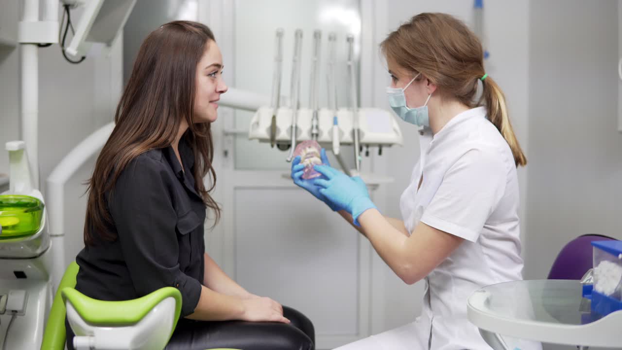 el dentista muestra una maqueta de la mandíbula del paciente. el modelo de la mandíbula. los huesos de la mandíbula. atributos y detalles en el consultorio de un dentista.