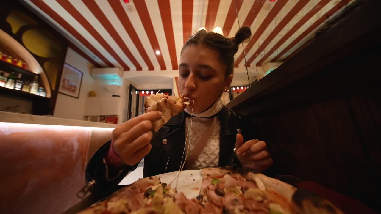 Una donna che mangia la pizza in un ristorante