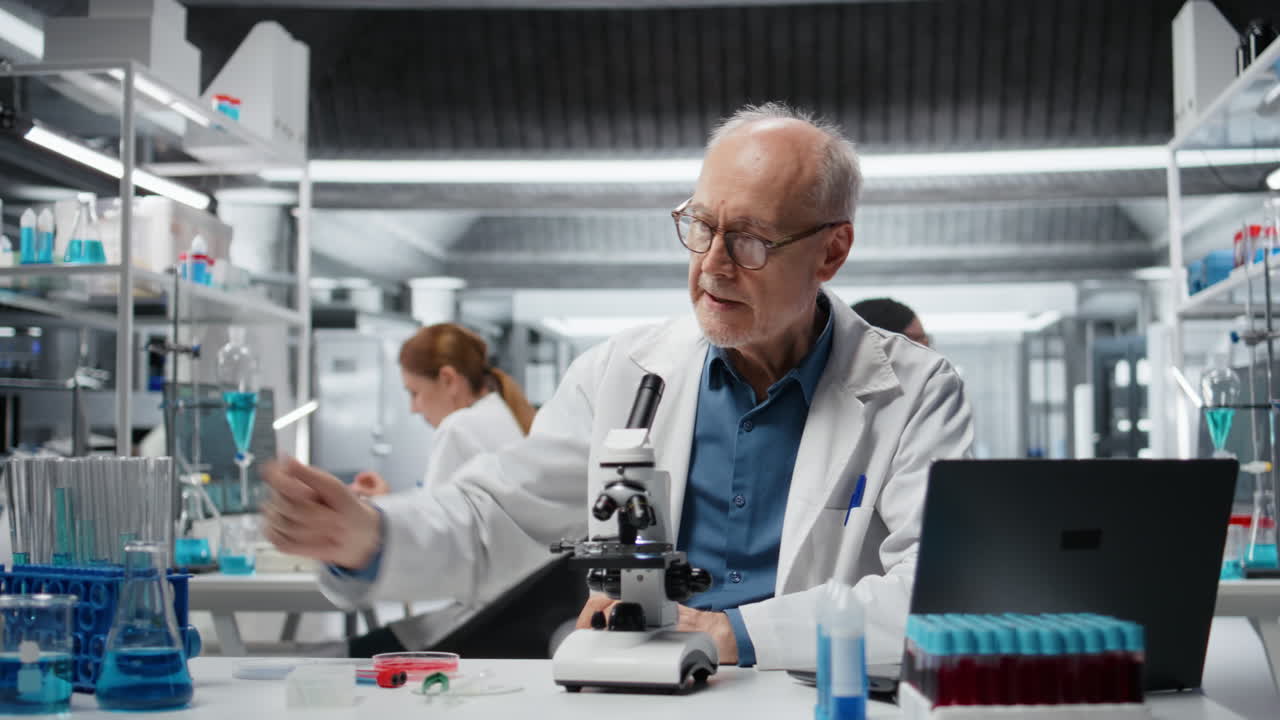 Chemical engineer in lab inspecting chemical compounds using laptop
