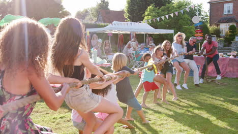 slow motion shot of game of tug of war at summer garden fete