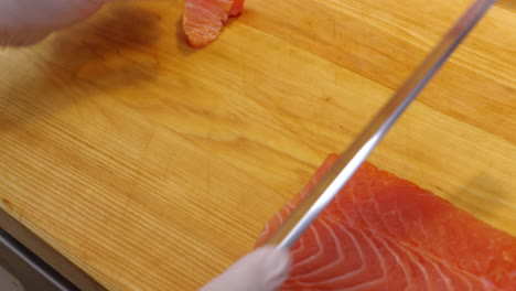 a chef slices a salmon fillet. raw seafood