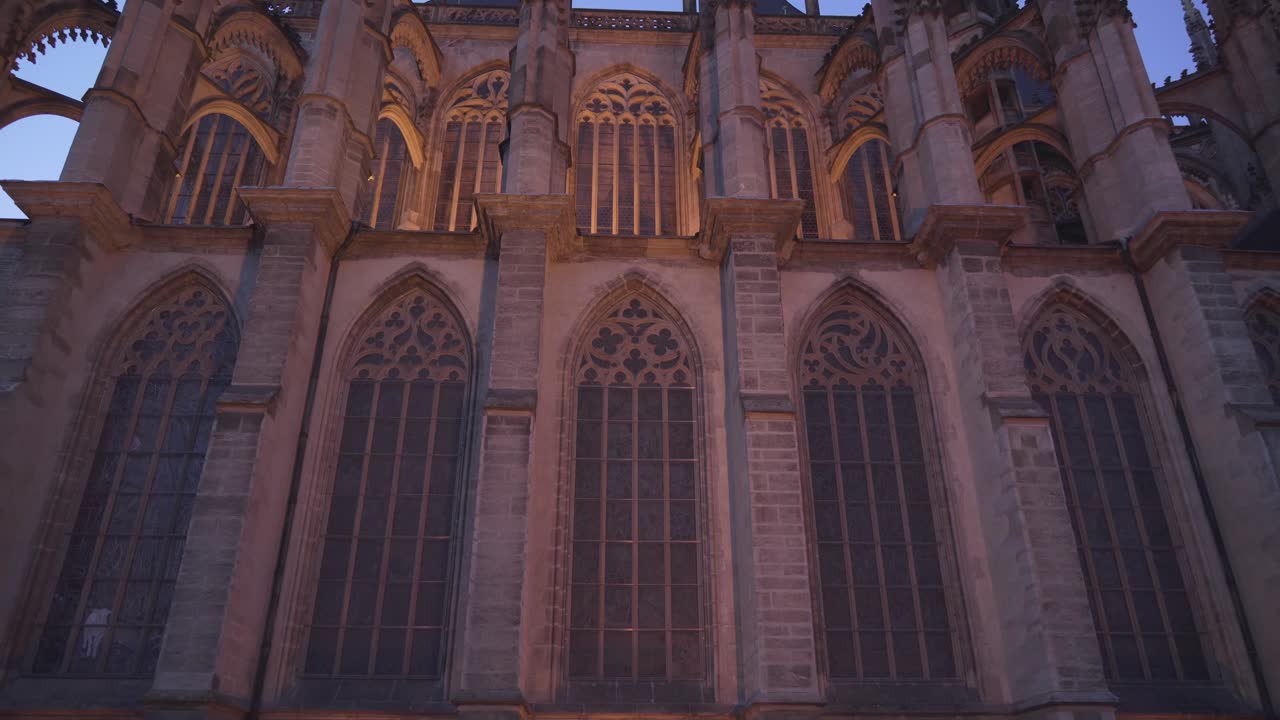 Gothic windows of St. Barbara's Cathedral in Kutna Hora, Czech Republic, tilting up evening shot with lights