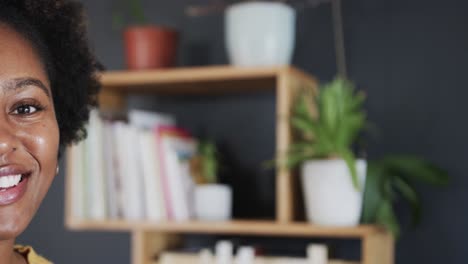 half portrait of happy african american woman smiling at home, with copy space, in slow motion