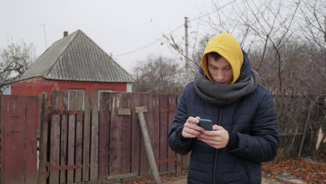 man using a smartphone outdoors in autumn